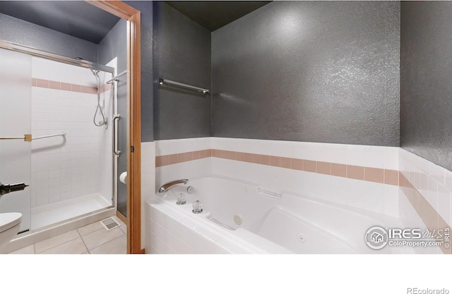 bathroom with tile patterned flooring, toilet, and plus walk in shower