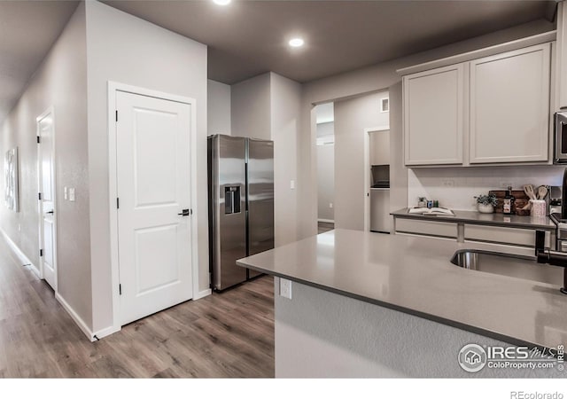 kitchen featuring hardwood / wood-style flooring, sink, backsplash, and appliances with stainless steel finishes