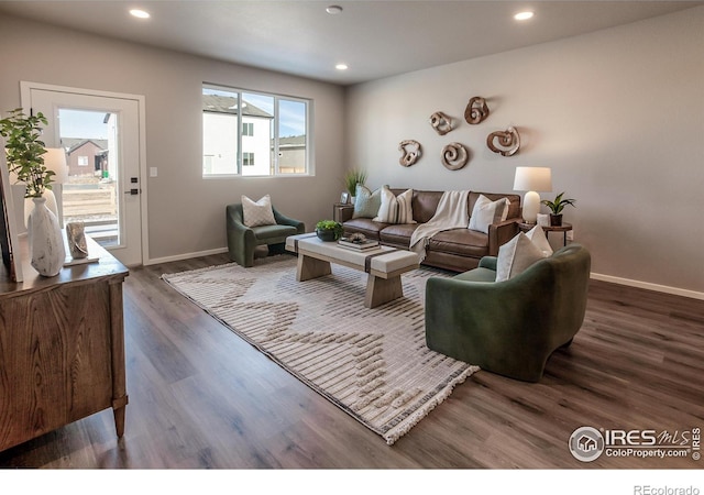 living room with dark hardwood / wood-style flooring and a healthy amount of sunlight