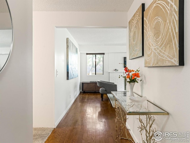 hallway with wood-type flooring and a textured ceiling