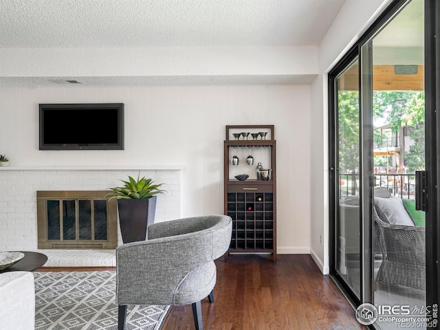 office space with dark hardwood / wood-style flooring, a textured ceiling, and a brick fireplace