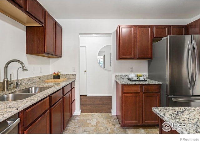 kitchen featuring light stone countertops, sink, and appliances with stainless steel finishes