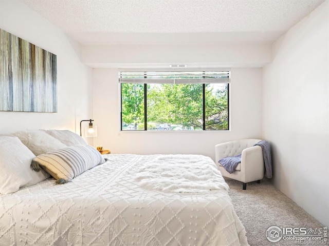 bedroom featuring a textured ceiling and carpet floors