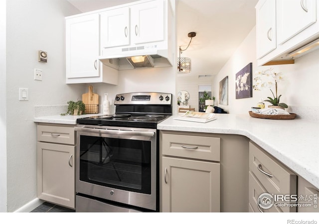 kitchen with white cabinets, electric range, a notable chandelier, and pendant lighting