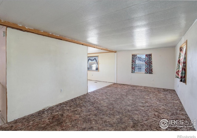 carpeted spare room featuring a textured ceiling