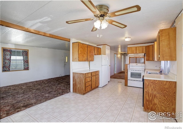 kitchen featuring a textured ceiling, white appliances, sink, and light carpet