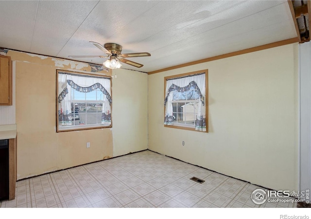 spare room featuring ceiling fan and a textured ceiling