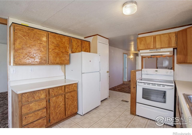 kitchen featuring white appliances and a textured ceiling