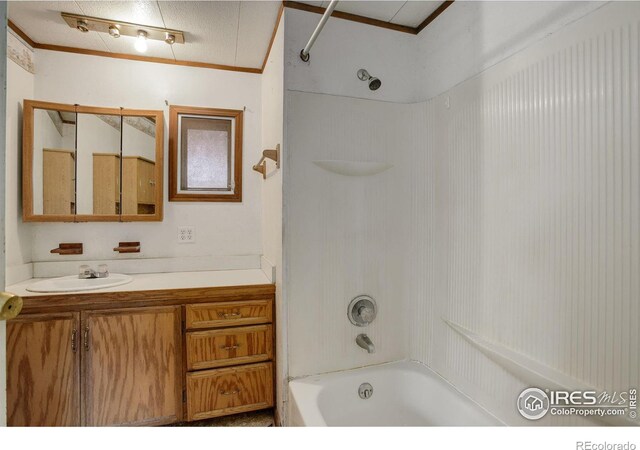 bathroom with washtub / shower combination, vanity, and ornamental molding