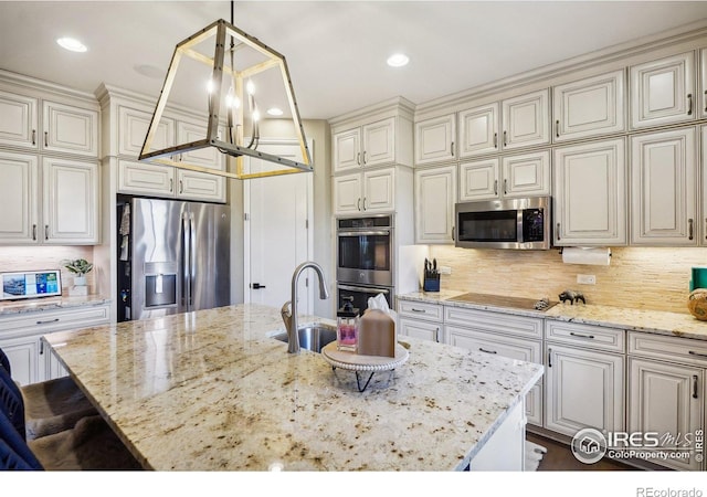 kitchen featuring a kitchen island with sink, decorative light fixtures, and appliances with stainless steel finishes