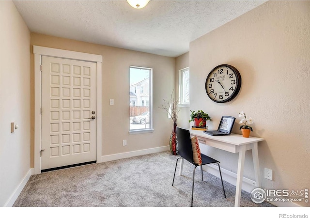 office featuring light colored carpet and a textured ceiling