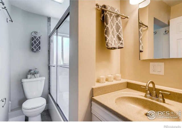 full bathroom with vanity, combined bath / shower with glass door, and toilet