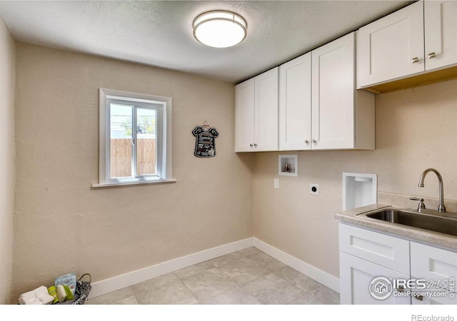 clothes washing area with sink, cabinets, a textured ceiling, hookup for a washing machine, and electric dryer hookup