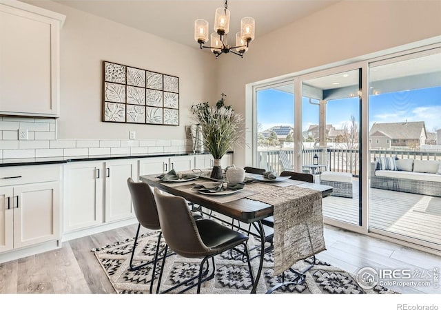 dining area with a notable chandelier and light hardwood / wood-style flooring