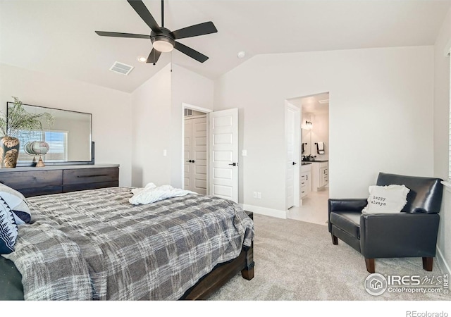 bedroom with connected bathroom, light colored carpet, vaulted ceiling, and ceiling fan