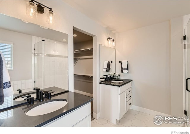 bathroom with tile patterned flooring, vanity, and a shower with shower door