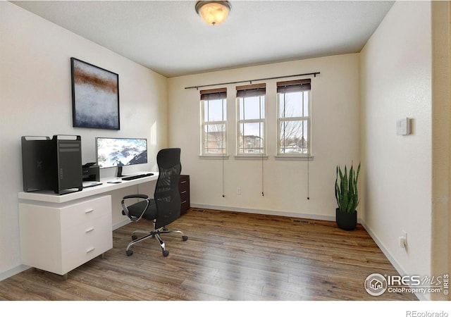 home office featuring wood finished floors and baseboards