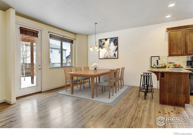 dining room with recessed lighting, a notable chandelier, light wood-style flooring, and baseboards