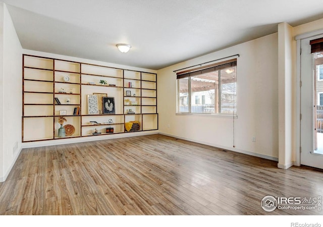 unfurnished room featuring baseboards and wood finished floors