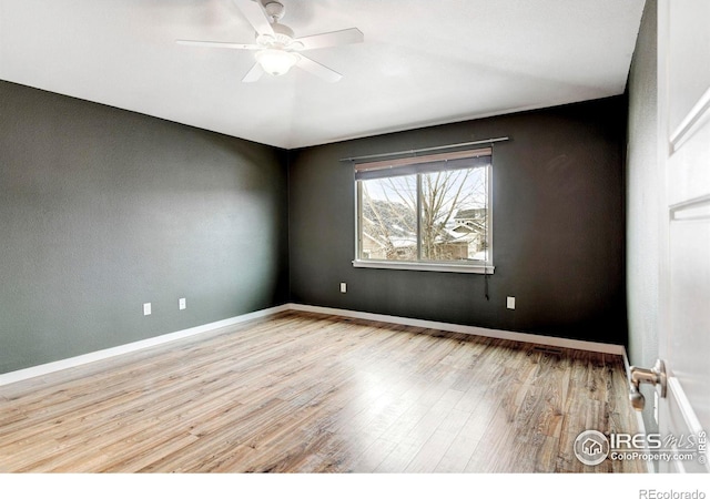 unfurnished room with baseboards, ceiling fan, and light wood finished floors