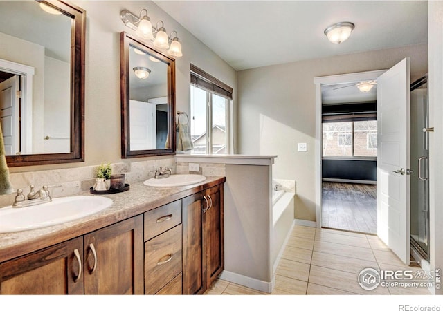 full bath with a healthy amount of sunlight, a sink, and tile patterned floors