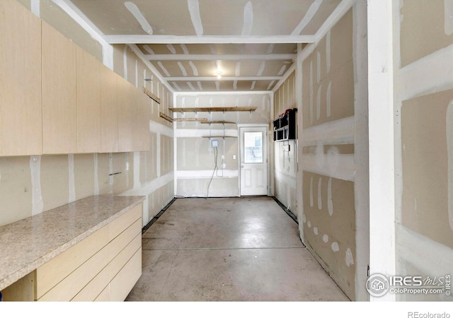 interior space with modern cabinets, concrete floors, light countertops, and light brown cabinetry