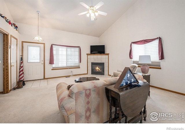 living room with vaulted ceiling, light colored carpet, a tile fireplace, and a healthy amount of sunlight