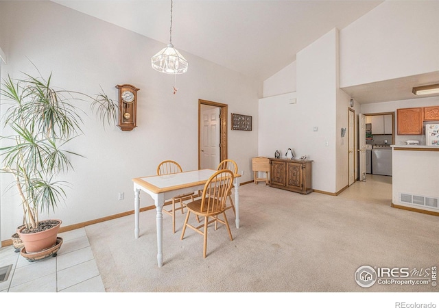 dining area with high vaulted ceiling and washer and dryer