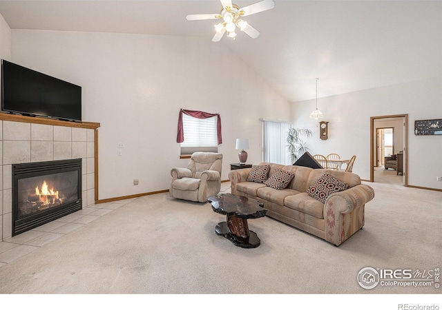 carpeted living room featuring ceiling fan, a tiled fireplace, and high vaulted ceiling