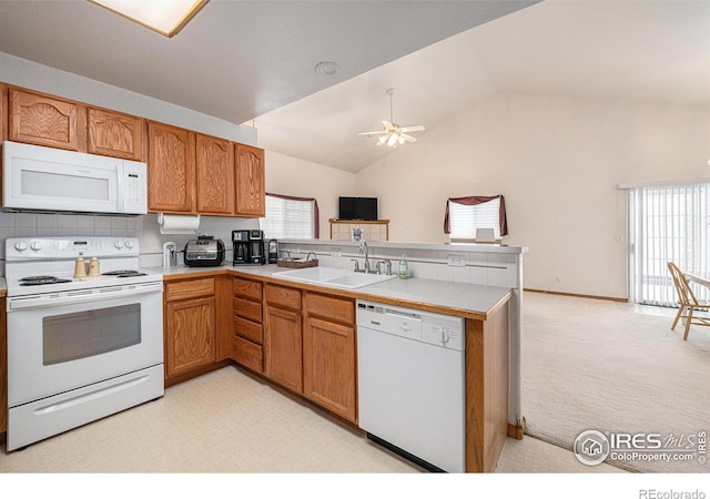 kitchen featuring lofted ceiling, white appliances, light carpet, kitchen peninsula, and ceiling fan