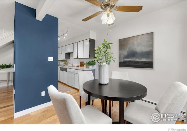 dining area featuring beam ceiling, light wood-type flooring, and ceiling fan