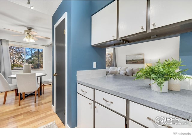 kitchen featuring ceiling fan, white cabinets, and light hardwood / wood-style floors