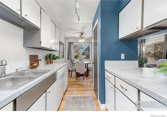 kitchen featuring white cabinets, sink, rail lighting, light hardwood / wood-style flooring, and ceiling fan