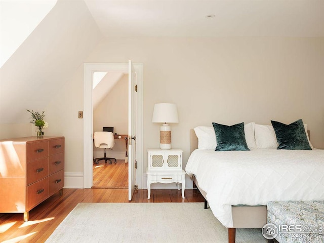 bedroom featuring hardwood / wood-style floors and vaulted ceiling