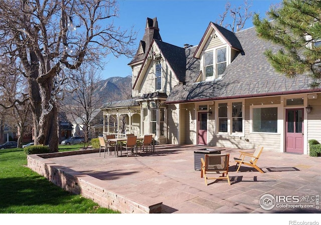 rear view of house with a mountain view and a patio