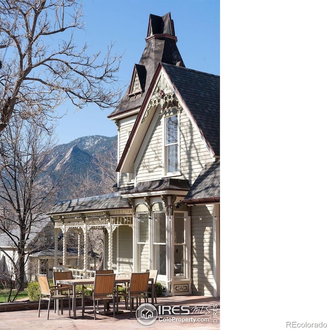 rear view of property with a mountain view and a patio area