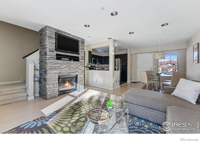 living room with sink and a stone fireplace