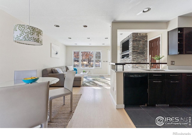 kitchen featuring sink, pendant lighting, dark hardwood / wood-style floors, and black dishwasher