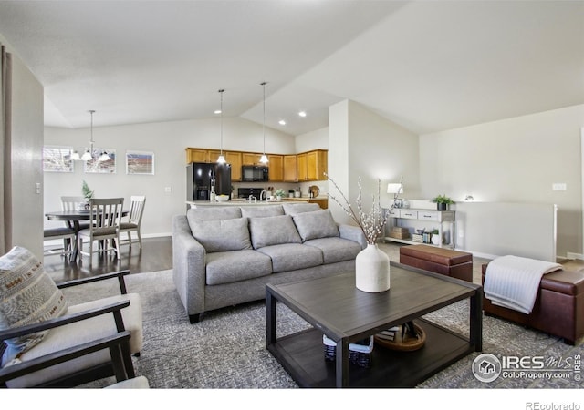 living room with vaulted ceiling, an inviting chandelier, and dark hardwood / wood-style floors