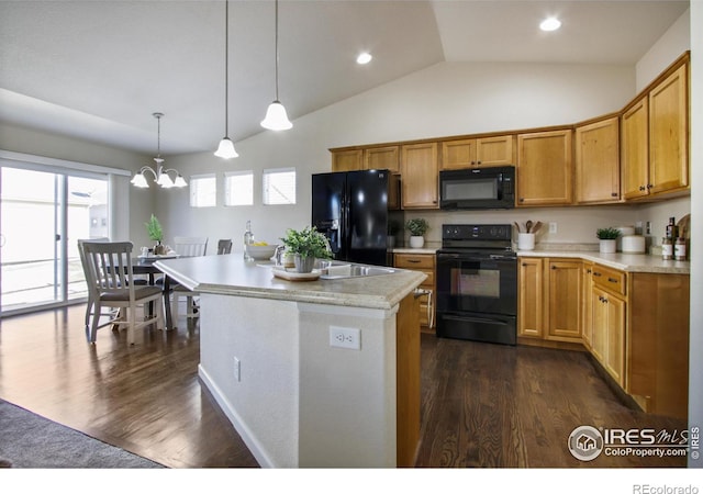 kitchen with black appliances, decorative light fixtures, a healthy amount of sunlight, and dark hardwood / wood-style floors