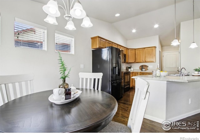 dining room featuring sink, a chandelier, lofted ceiling, and dark hardwood / wood-style flooring