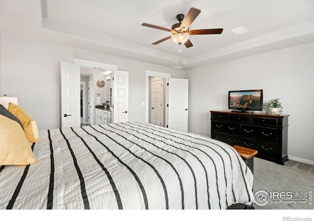 carpeted bedroom featuring ceiling fan and a raised ceiling