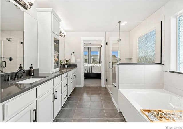 bathroom with plus walk in shower, vanity, and plenty of natural light