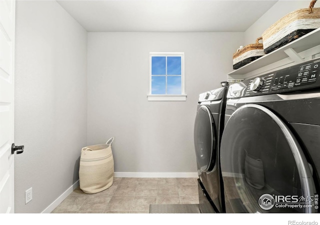 laundry area with washing machine and dryer and light tile patterned floors