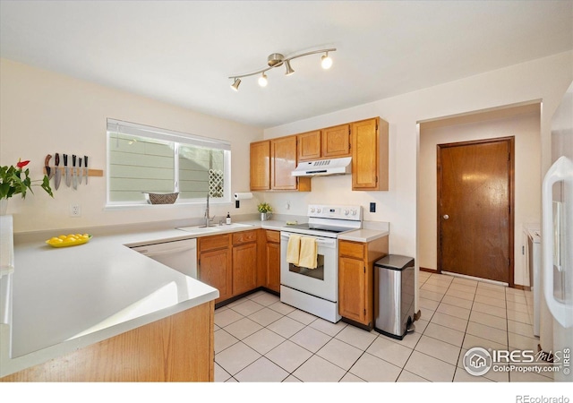 kitchen featuring sink, white appliances, light tile patterned floors, and kitchen peninsula