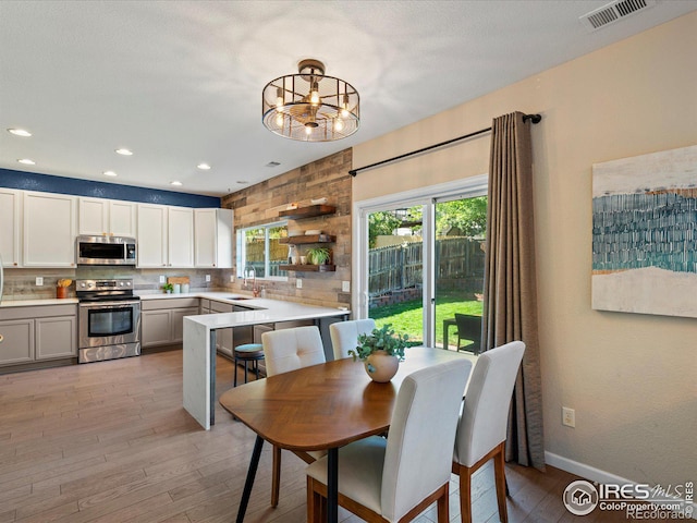 dining area with sink and light wood-type flooring