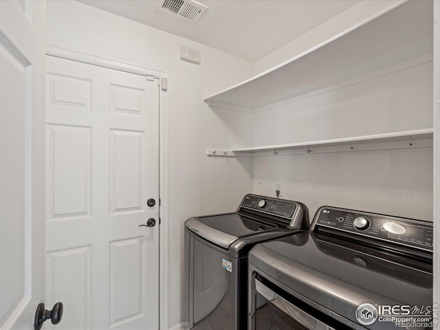 clothes washing area with washing machine and dryer