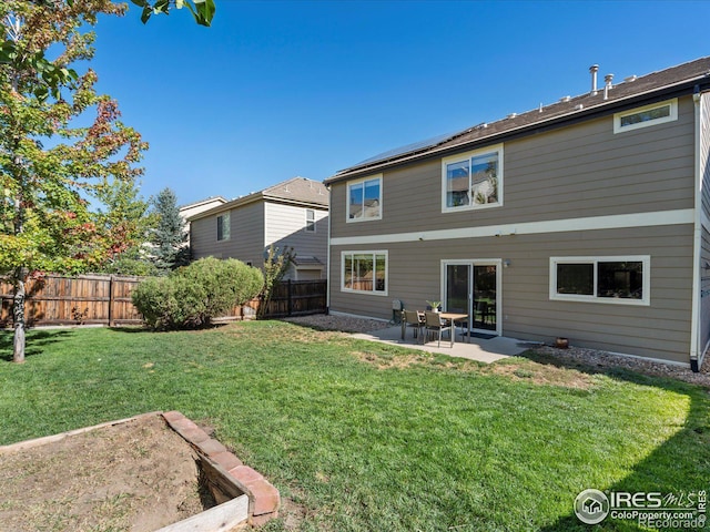 rear view of property featuring a yard and a patio