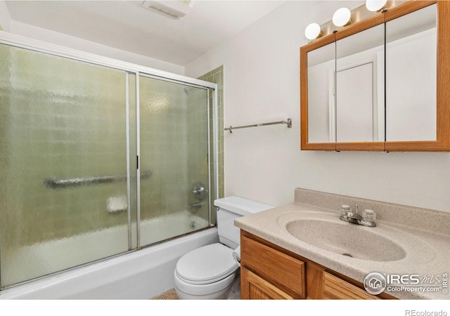 full bathroom featuring enclosed tub / shower combo, vanity, and toilet