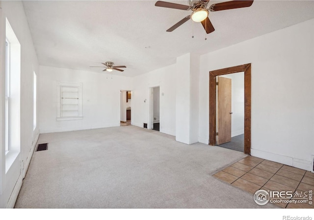 unfurnished room with ceiling fan, a textured ceiling, and carpet flooring